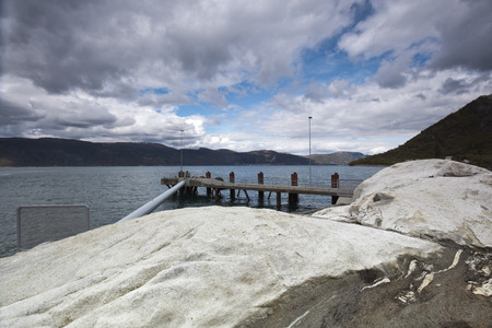 viewfrom a stony coastline in norway of an empty landing stageの写真素材