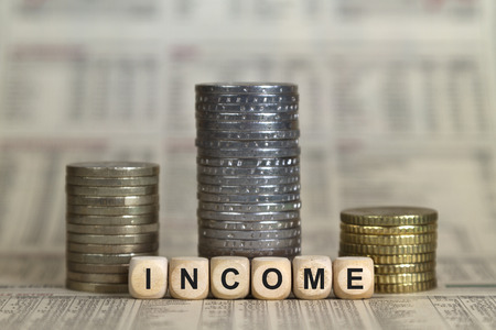 Income winner's pedestal from coins on a business newspaperの写真素材