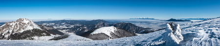 Panorama from top of winter mountains under clear blue sky. Beautiful Big Rozsutec hill on left...