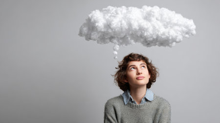 Young woman with cloud above her head looking up at copyspaceの素材