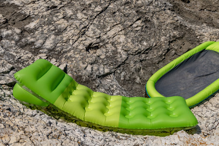Green mattress on a pebble beach occupied by tourists on the beach in Croatiaの写真素材