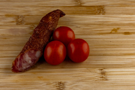 Long dried wild boar sausage on a wooden cutting board, healthy foodの写真素材
