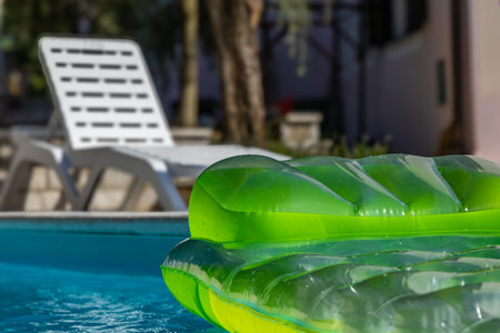 Green inflatable mattress in the poolの写真素材