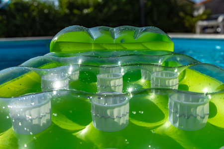 Green inflatable mattress in the poolの写真素材