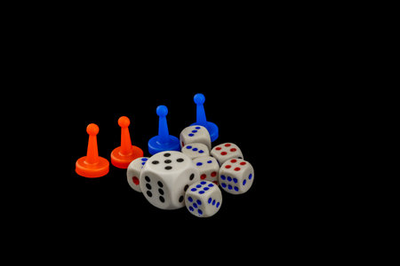 Colorful game pieces and dice on black background relaxing gambling game with diceの写真素材