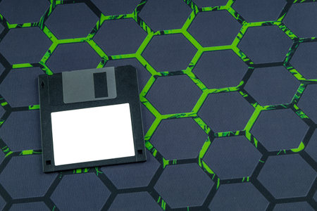 Colorful old floppy disks for old 16-bit and 8-bit 3.5-inch computers arranged on a black keyboard...
