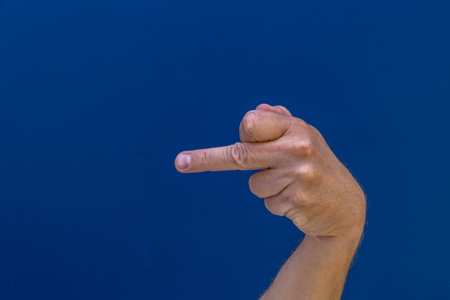 A symbol that is offensive to others, a raised middle finger, a symbol of lack of cultureの写真素材