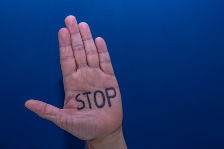 A hand on a blue background of a man calling for help, a symbol, a cry for helpの写真素材