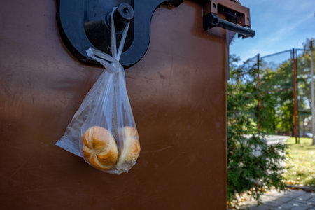 Stale bread in a plastic bag thrown into the trash, food in the trash canの写真素材