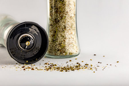 Salt and pepper in a glass container with a grinder, salt shaker, pepper shaker, salt shaker, pepper...
