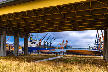 Tall cranes in the port, unloading goods from containers from ships, cargo port in Gdynia