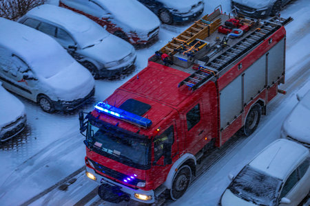 Red fire truck arrives at the scene on a winter road covered with snow