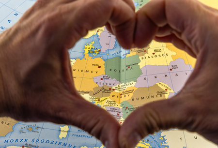 Hands folded in the shape of a heart against the background of a map of Poland, love for the homeland, independence dayの写真素材
