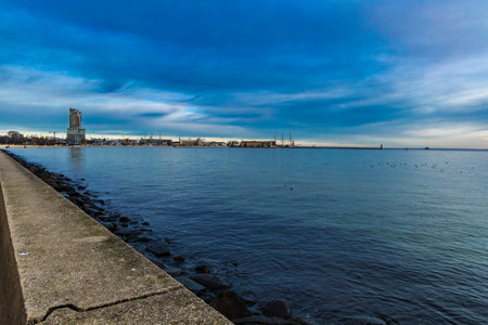 Walking along the Baltic coast towards Gdynia, woman in winter jacket, panorama of Gdyniaの写真素材