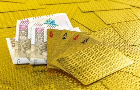 500 zloty banknotes as winnings in a poker game, golden poker playing cards in the hands of a casino...