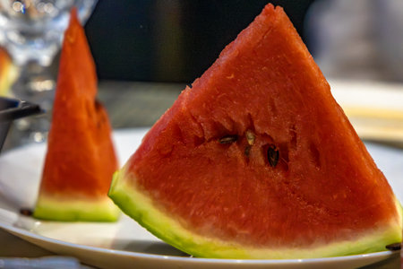 Triangular piece of red juicy watermelon on a plate, close-up, fruit,