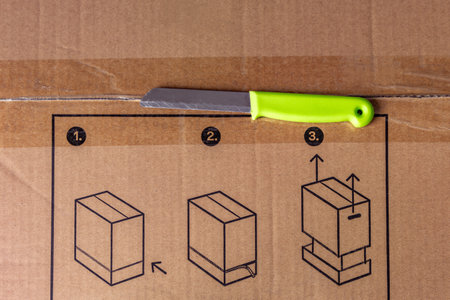 Unpacking a large gray cardboard box, knife on a cardboard boxの写真素材