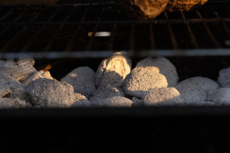 Two baked potatoes on the grill, cooked in their skins over the fireの写真素材