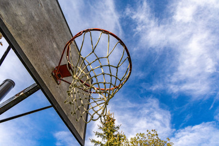 An old basketball hoop against a blue sky