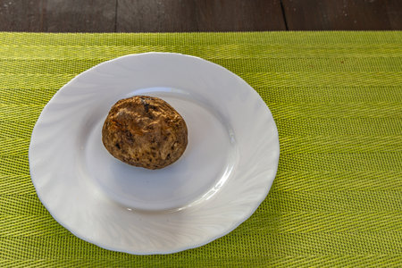 Potatoes from the fire with butter and salt on a plate, grilled dishes, grilled potatoes in their...