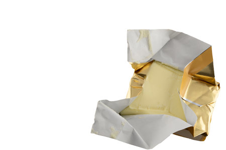 A cube of yellow butter on a white background, cutting butter for breakfastの写真素材