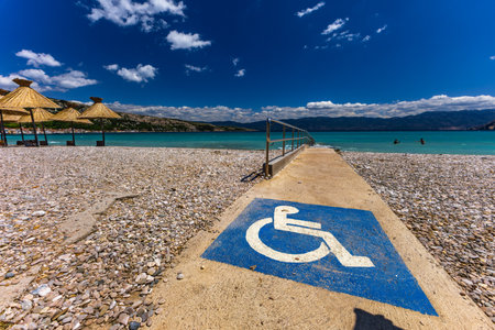 Beach adapted for disabled people moving in wheelchairs, concrete entrance to the Adriatic Sea with...