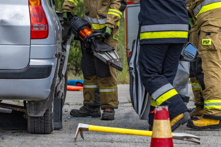 Firefighters and rescuers cut open a car body during a rescue operation, the scene of a road accidentの写真素材