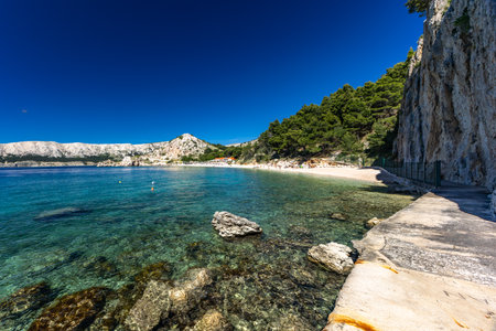Jablanova Beach on the island of KRK in Croatia, blue trail leading to an empty pebble beach, wild nature and lush Mediterranean vegetation, panorama overlooking the Adriatic Sea,の写真素材