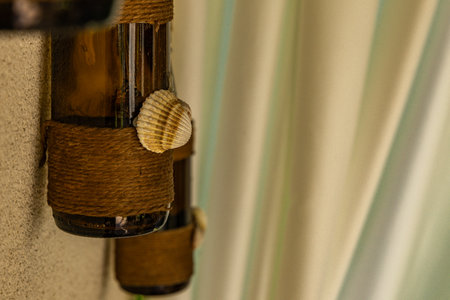 Wine bottle with a conch shell on a background of curtainsの写真素材