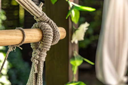 Gray Brazilian swing chair hanging on a wooden structure on the terrace, a place to relax in front of the house, a swing for children and adultsの写真素材