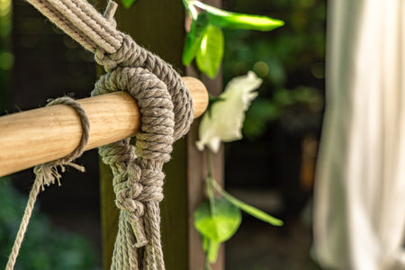 Gray Brazilian swing chair hanging on a wooden structure on the terrace, a place to relax in front of the house, a swing for children and adultsの写真素材