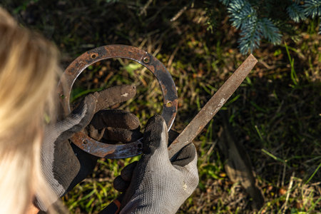 Woman cleans rust from rusty old garden lamp with sandpaper, renovation of old metal parts