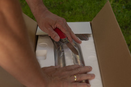 Man takes electric grill out of cardboard box, unpacking mail, assembling electric grillの写真素材