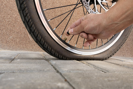 Flat tire on electric bike, pumping air into bike inner tube, bike inspection and repair before the seasonの写真素材