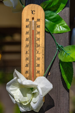 Wooden mercury thermometer showing very high temperature in summer on the front porch, a heat wave dangerous to healthの写真素材