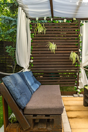 Homemade garden furniture from pallets, wooden veranda with curtains, terrace in front of the summer house.の写真素材