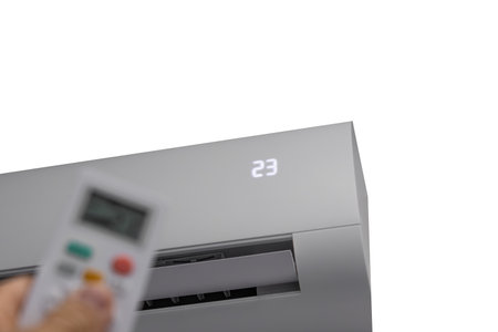 Remote control for air conditioning in man's hands, air conditioning device on white backgroundの写真素材