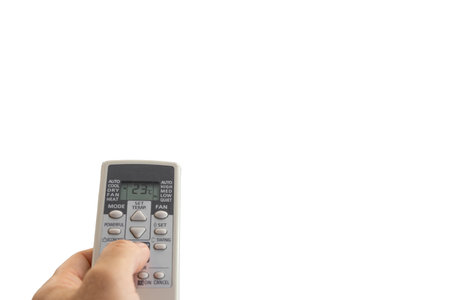 Remote control for air conditioning in a man's hands, remote control for air conditioning on a white backgroundの写真素材