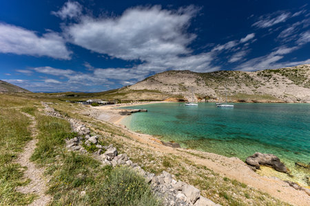 Panorama of the bay with the Vela Luka beach below, view of the beach from the top of the mountain, rocky trail leading to the picturesque beachの写真素材