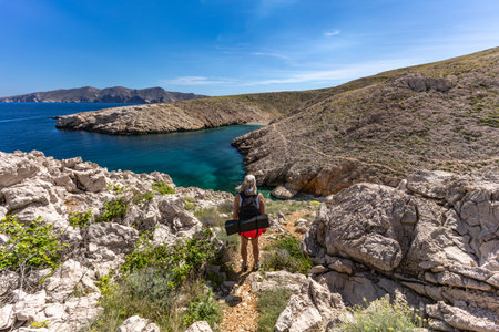Woman with backpack hiking on a rocky mountain trail, Balos beach, Crete, Greeceの写真素材