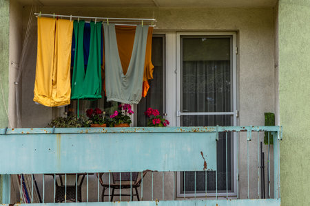 Colorful trousers, winter long johns, hanging on the balcony of a multi-family building, drying laundry at the stationの写真素材