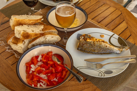 A traditional meal in Croatia, fried fish, olive oil with garlic, bread and fresh tomatoes, a healthy eating style Croatiaの写真素材