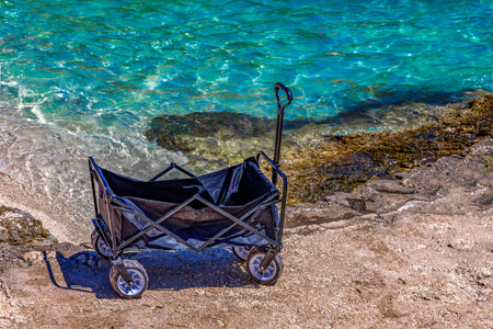 A beach cart with wheels, a cart for transporting toys, food, mattresses, and sun loungers to the beach.の写真素材