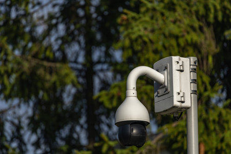 City monitoring system, cameras in a public park, devices recording people in a park on a street in...