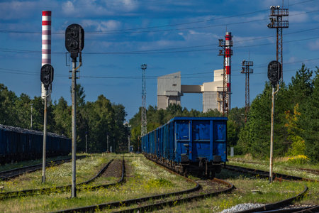 Two trains on a siding waiting to be loaded in front of the factory, empty wagons stopped before...