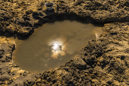 Playing in the sand at Paradise Beach in Lopar, Croatia, a hole dug on the beach filled with water, Rabの写真素材
