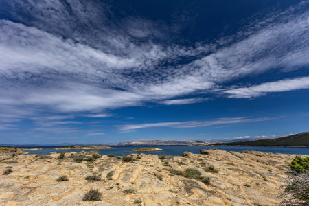 Azure water in the Adriatic Sea, rocky coast of the island of Rab, cloudy, threatening sky, panorama of the island, Strucic beachの写真素材