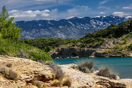 Azure water in the Adriatic Sea, rocky coast of the island of Rab, cloudy, threatening sky, panorama of the island, Strucic beachの写真素材