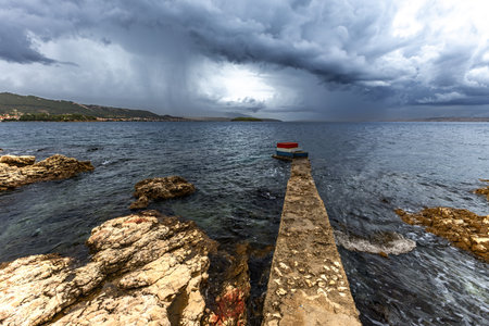 Panorama and view of the town of Rab from the bay, four towers, church tower and bell tower, cloudy stormy sky Croatiaの写真素材
