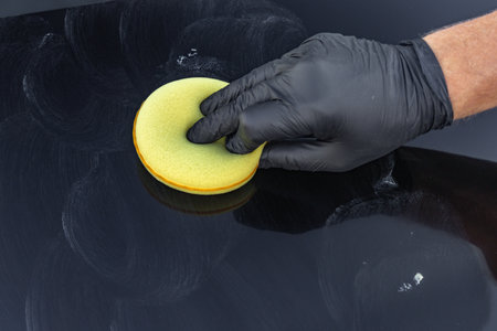 A soft sponge pad for washing a car in a man's hand, car detailing washingの写真素材